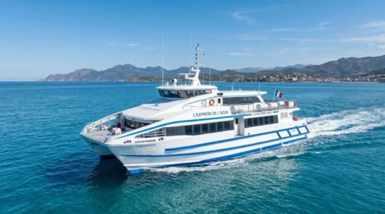 Un ferry à grande vitesse navigue sur une mer Méditerranée calme sous un ciel bleu lumineux